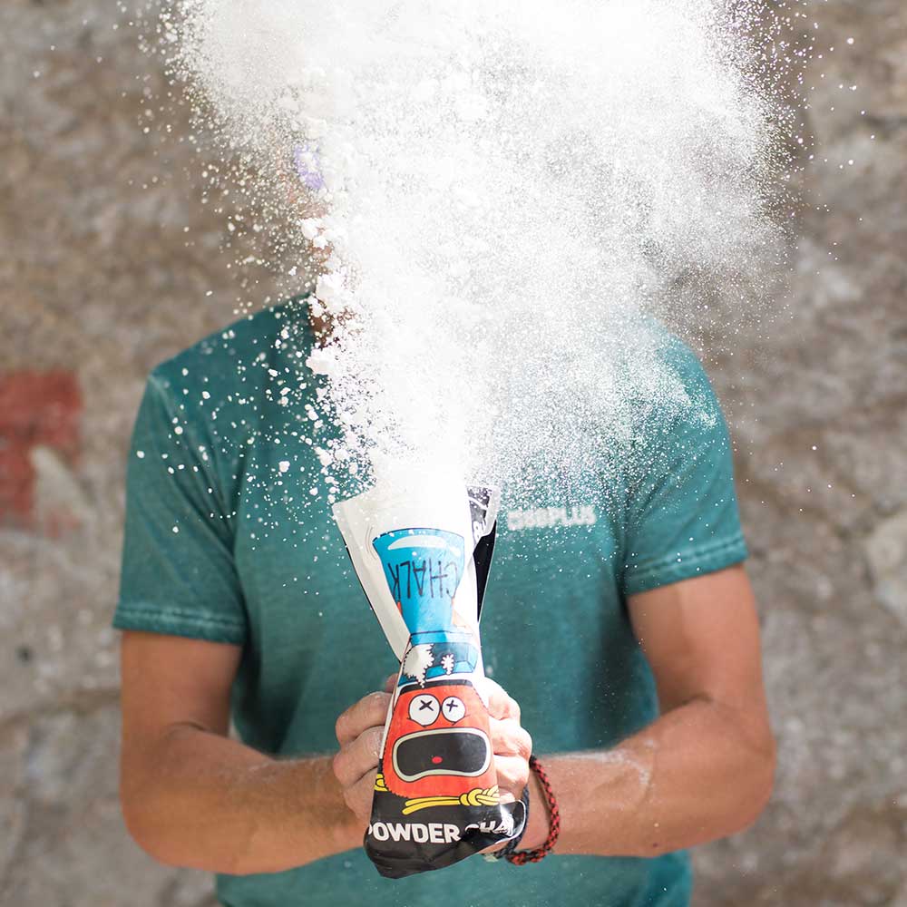 Rock Climbing Chalk spraying vividly through the air as a climber squeezes his chalk bag and sends the climbing chalk flying