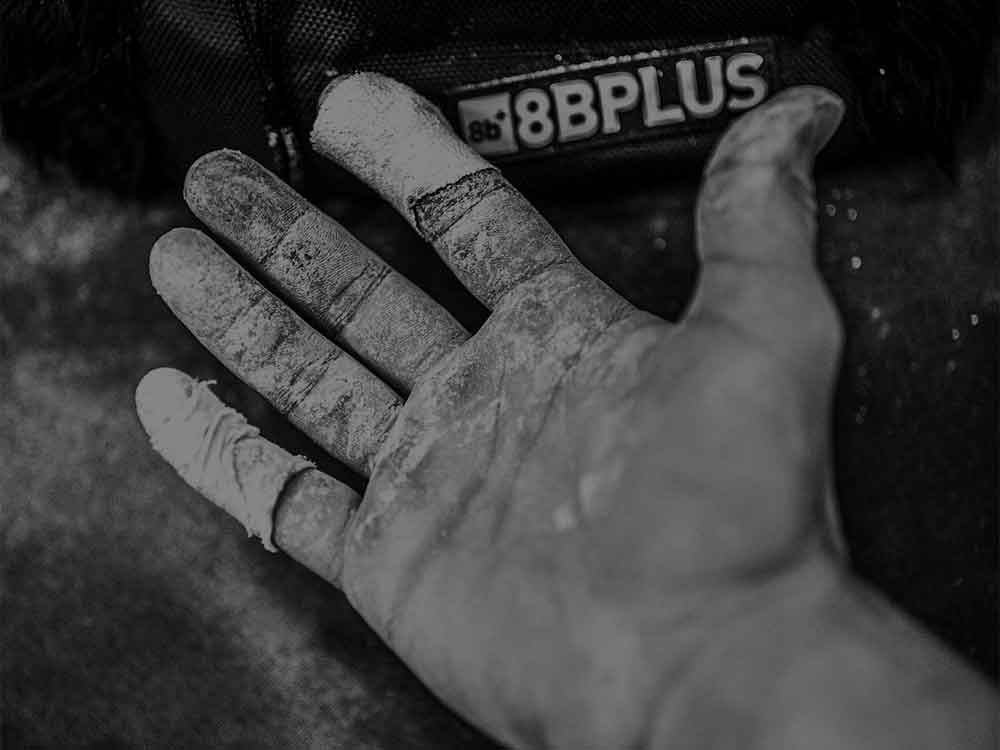 Climber applying chalk for rock climbing with 8BPLUS powder chalk